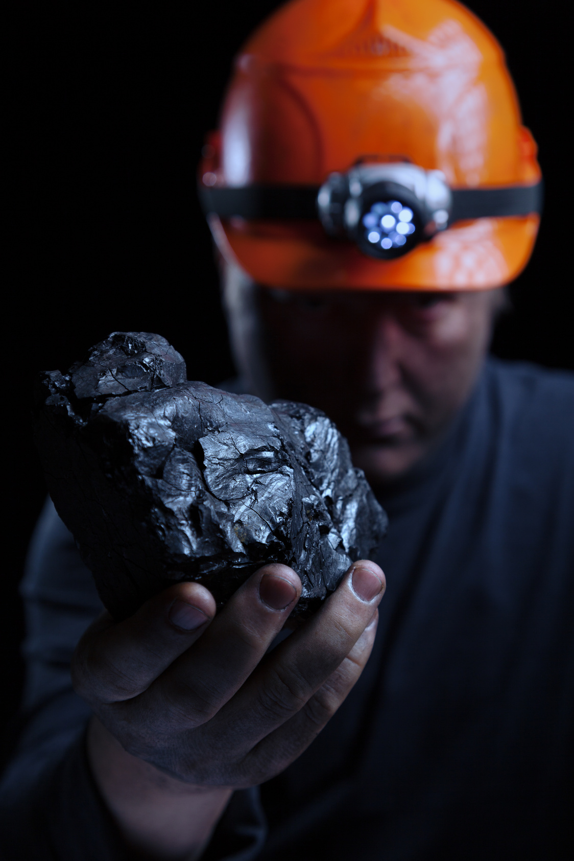 A coal miner holding a piece of coal
